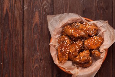 Tavuk kanadı: bal, susam, zencefil. Tahta bir masada..