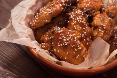 Tavuk kanadı: bal, susam, zencefil. Tahta bir masada..