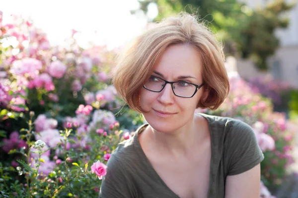Dívka Brýlích Spočívá Blízkosti Květin Měkké Slunné Pozadí — Stock fotografie