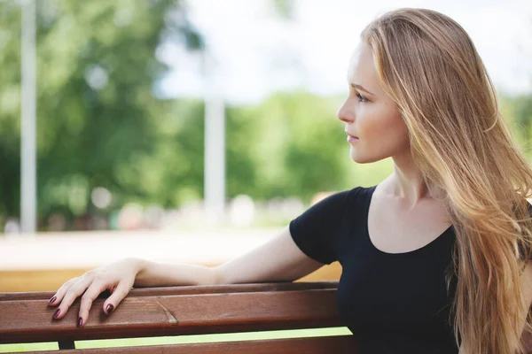 Şortlu genç bir kız ve şehirde siyah bir konu. Parlak duygular, yaşam tarzı, güneşli bir gün.