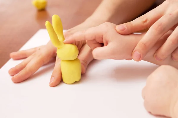 The child is playing with plasticine. Hand-made game.