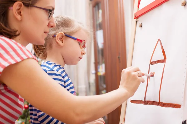 Mom teaches daughter to paint house. paints on canvas