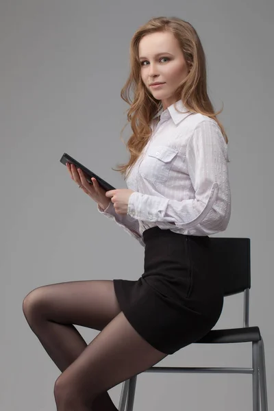 Retrato Negócios Uma Menina Bonita Sentado Numa Cadeira Fundo Cinza — Fotografia de Stock