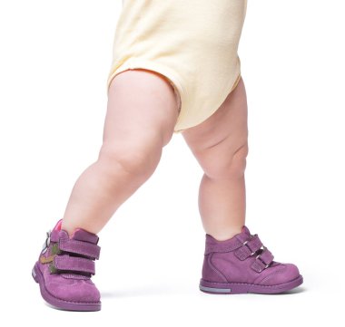 Şık bebek botların içine giriyor. Beyaz bir arka grupta izole edilmiş.