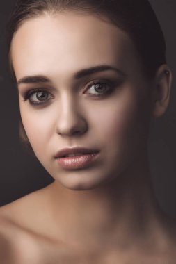 Karanlık arka planda güzel bir kızın stüdyo portresi.