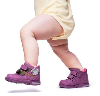 Şık bebek botların içine giriyor. Beyaz bir arka grupta izole edilmiş. 