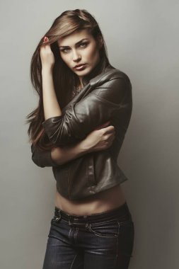 Güzel kız stüdyoda gri arka planda poz veriyor. Moda portresi. Makyaj malzemesi. Uzun saçlı.. 