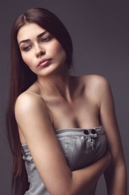 Güzel kız stüdyoda gri arka planda poz veriyor. Moda portresi. Makyaj malzemesi. Uzun saç. Renkli fotoğraf.