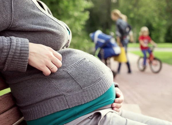 Uma Mulher Grávida Sentada Num Banco Fundo Menina Bicicleta Tempo — Fotografia de Stock