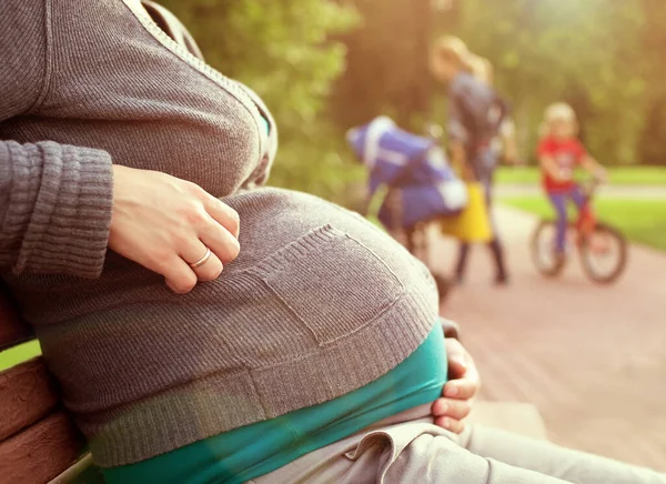 Gravid Kvinna Sitter Bänk Bakgrunden Den Lilla Flickan Cykel Varmt — Stockfoto