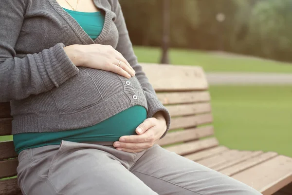 妊娠中の女性がベンチに座って — ストック写真