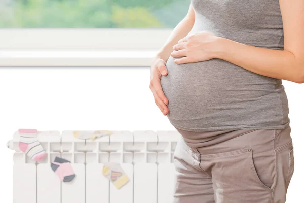 Mulher Grávida Antes Uma Janela Com Aquecedor Isolado Branco — Fotografia de Stock