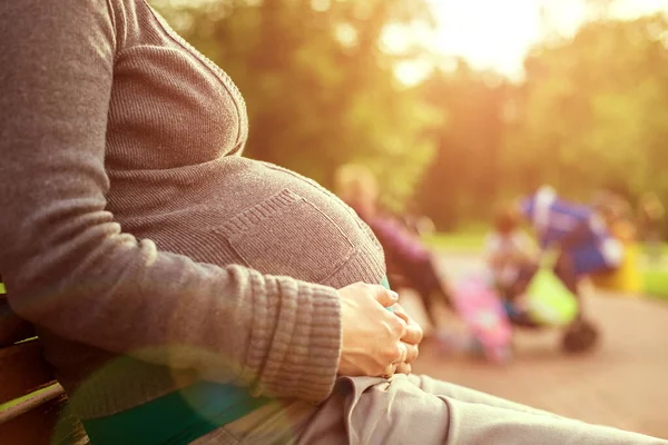 Gravid Kvinna Sitter Bänk Bakgrunden Barnen Leker Varmt Väder — Stockfoto