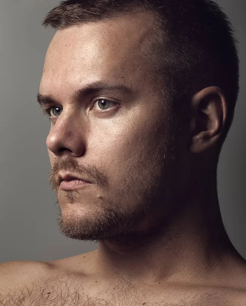 Gri arka plandaki traşlı adamın portresi değil.