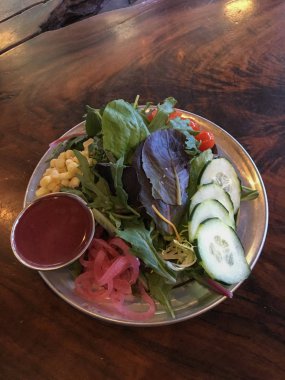 Taze yeşil organik salata kaplama ve salatalık, domates, lettus ve Mısır ile hizmet vermeye hazır.