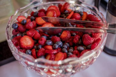 Bir kase çilek ve kristal kase maşa ile mavi çilek.