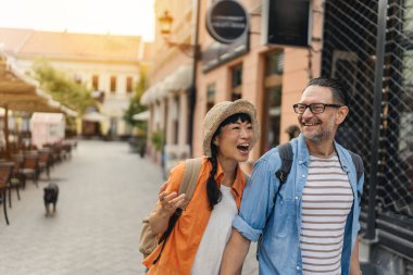 Smiling couple walking outdoors enjoying sunny urban street together