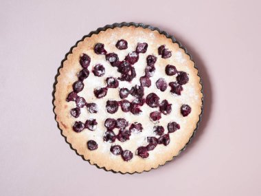 Pastel pembe arka plan üzerinde tüm ev yapımı kiraz kek. Çok az. Düz yatıyordu.