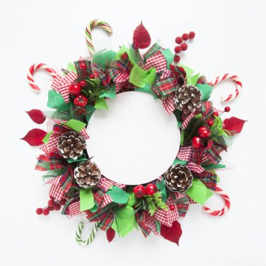 Noel çelenk renkli şeritler, koniler, şekerler, Atatürk çiçeği yaprakları ve yapay holly Karpuzu kopya alanı ile yapılmış. Beyaz arka plan. Düz yatıyordu.