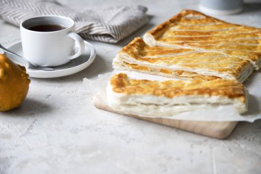 Puf böreği pasta kabak, soğan ve peynir gri arka plan üzerinde. Çok az. Seçici odak. Kopya alanı. 