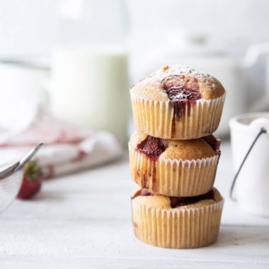 Beyaz masada buzlu çilekli kekler.