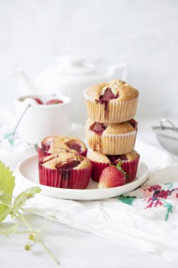 Beyaz arka planda taze pişmiş çilekli kekler. 