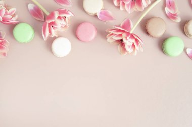 Renkli makarna veya makarna kek ve lale pastel pembe arka plan üzerinde kopya alanı ile. Düz yatıyordu.
