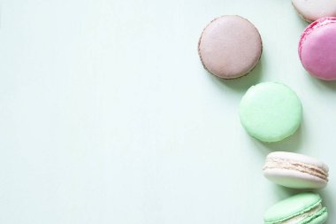 Pastel yeşil arka planda renkli makarna veya makarna kek.