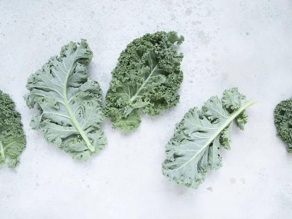 Fresh green kale leaves on rustic background.