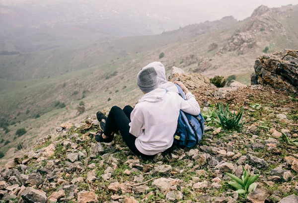 bir dağ uçurumun üzerinde oturan aşık çift