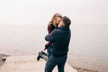 Bir çift rıhtımda sarılıyor.