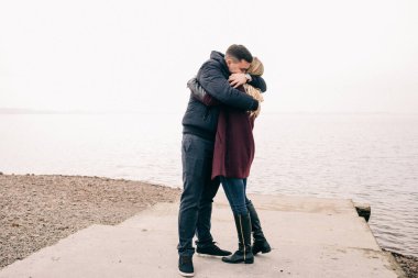 Bir çift rıhtımda sarılıyor.