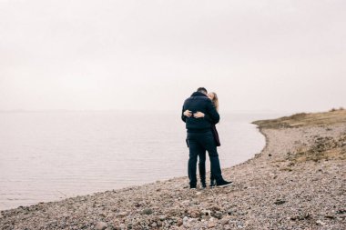 Bir çift rıhtımda sarılıyor.