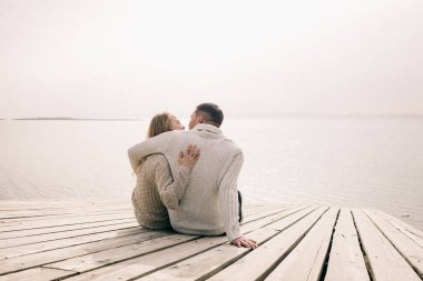 Bir çift rıhtımda sarılıyor.