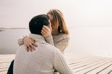 Bir çift rıhtımda sarılıyor.