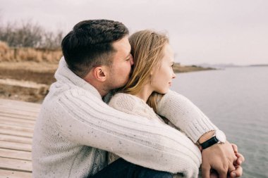 Bir çift rıhtımda sarılıyor.