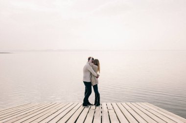 Bir çift rıhtımda sarılıyor.