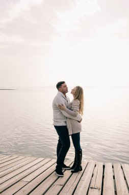 Bir çift rıhtımda sarılıyor.