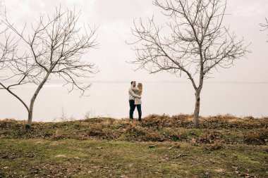 Bir çift rıhtımda sarılıyor.