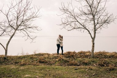 Bir çift rıhtımda sarılıyor.