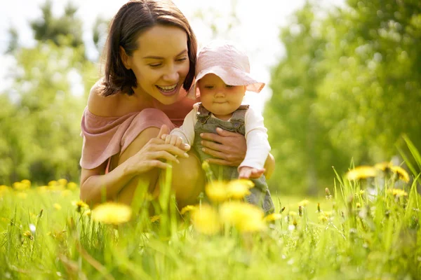 Mother and daughter on a meadow with dandelions — Stock Photo, Image