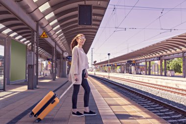 bir genç kız tren istasyonundaki bavulla portresi