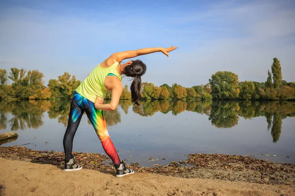 Een Jonge Vrouw Stretching Voor Joggen Een Meer — Stockfoto