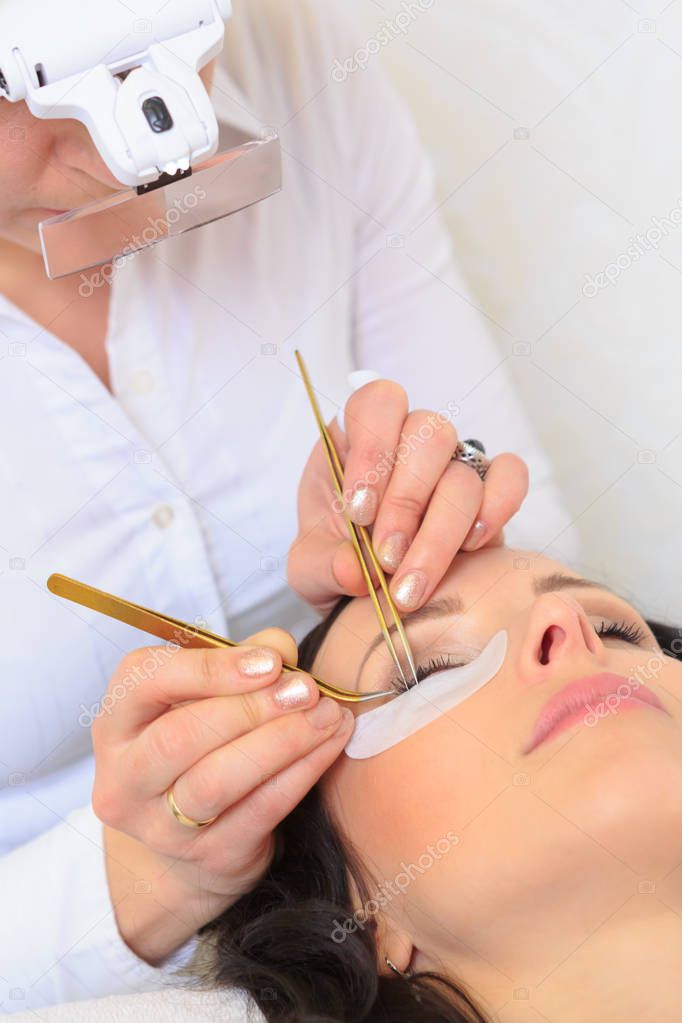 closeup of a female face by receiving of eyelash lengthening at the beauty salon