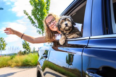 ailesi ve bir köpekle birlikte arabayla seyahat bir kız