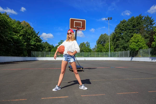 一个十几岁的女孩在公园里打篮球 — 图库照片