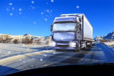 bir kamyon karlı yolda, kargo ve nakliye şirketleri için sembolik resim