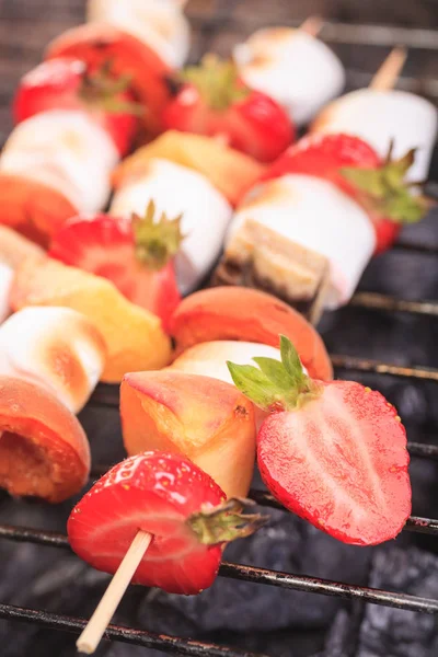 close up shut of marshmallows and fruits on the grill