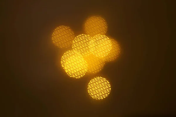 暗い背景上の幾何学的な要素のパターンを持つ美しいゴールドのボケ味 — ストック写真