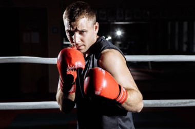 Genç atletik adam boks ringde boks eldiven